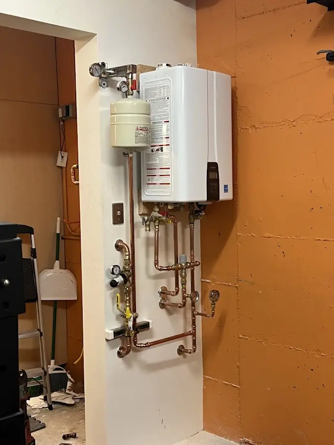 Plumbing technician inspecting water heater connections in Monroeville